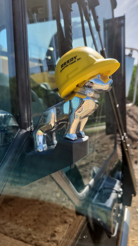 Reedy Concrete Construction, Inc. hard hat on a chrome hood ornament