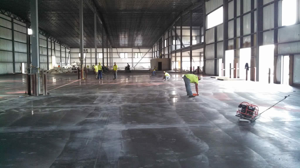 Crew finishing a large warehouse concrete floor